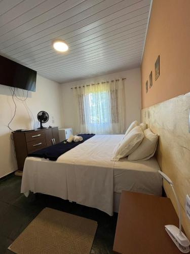 um quarto com uma cama grande e uma janela em Pousada Recanto das Flores em Aiuruoca