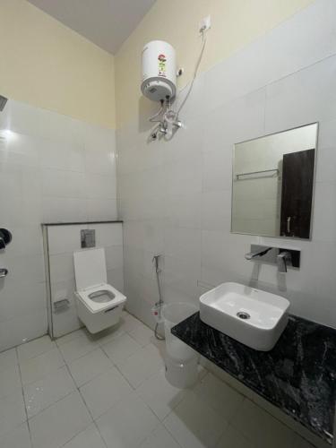 y baño con aseo, lavabo y espejo. en Hotel LS Haveli, en Pushkar