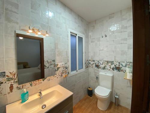 a bathroom with a toilet and a sink and a mirror at Casa Kanete in Cala