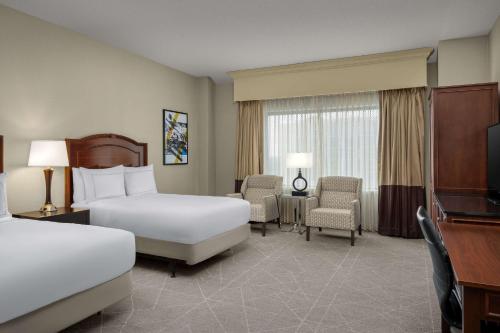 um quarto de hotel com duas camas e uma televisão em DoubleTree by Hilton Chicago O'Hare Airport-Rosemont em Rosemont