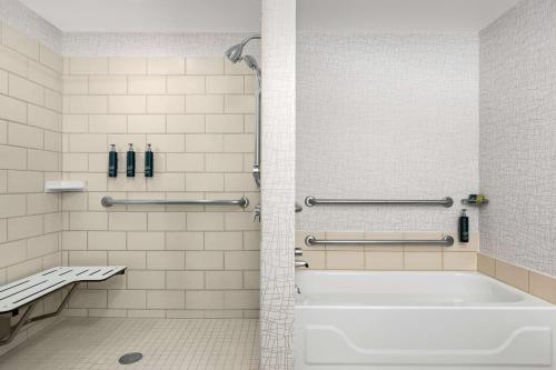 uma casa de banho com uma banheira branca e um chuveiro em DoubleTree by Hilton Chicago O'Hare Airport-Rosemont em Rosemont
