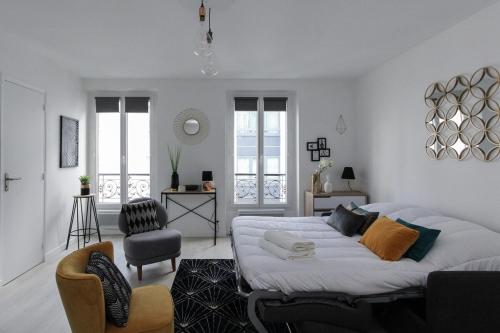 um quarto branco com uma cama e cadeiras em Paris - Studio - Pere-Lachaise em Paris