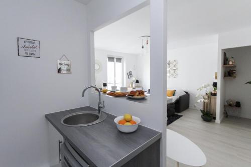 uma cozinha com um lavatório e uma taça de fruta no balcão em Paris - Studio - Pere-Lachaise em Paris