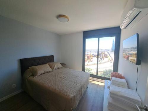 een slaapkamer met een bed en een groot raam bij 2 dormitorios, parking, ¡nuevo! in Montevideo