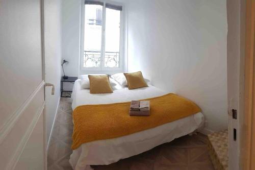 une chambre avec un grand lit avec une fenêtre dans l'établissement Bastille - Lappe - Quartier anime, à Paris
