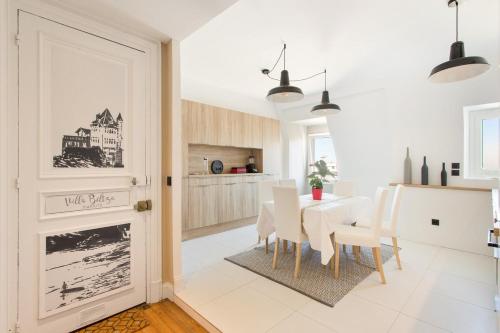 une salle à manger blanche avec une table et des chaises blanches dans l'établissement Biarritz - Clemenceau - Centre ville - Plage, à Biarritz