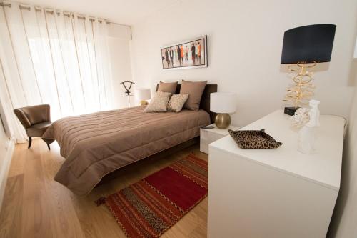 une chambre avec un lit et une table avec une lampe dans l'établissement Luxueux pied à terre -Trocadéro - Tour Eiffel et Champs de Mars, à Paris