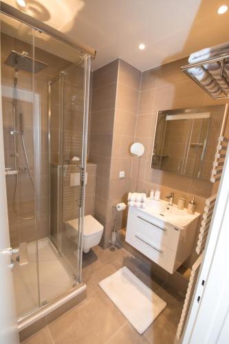 une salle de bain avec une douche, un lavabo et des toilettes dans l'établissement Luxueux pied à terre -Trocadéro - Tour Eiffel et Champs de Mars, à Paris