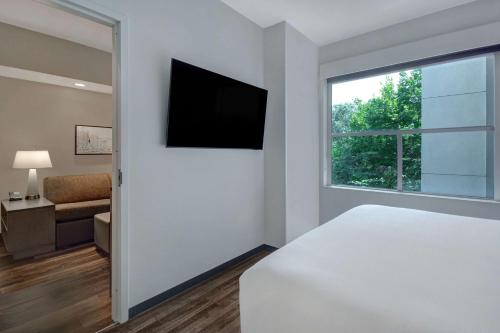 a bedroom with a bed and a flat screen tv at Hyatt House Mall Of America Msp Airport in Bloomington
