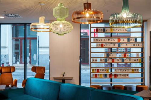 a lobby with a blue couch and chandeliers at Hampton By Hilton Budapest City Centre in Budapest