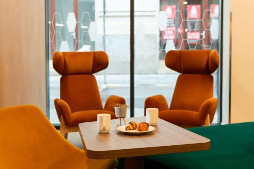uma mesa e cadeiras com um prato de comida em Hampton By Hilton Budapest City Centre em Budapeste