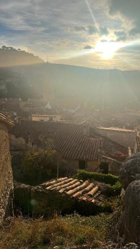 a view of a city from a hill with the sun setting at La Fonda de Xiva in Chiva de Morella