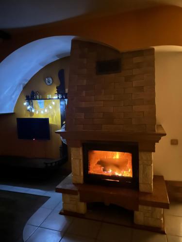 a brick fireplace in a living room with a tv at Grisli house in Gauja