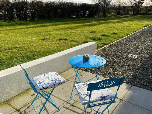 two chairs and a blue table and a table at The Boathouse in Donaghadee