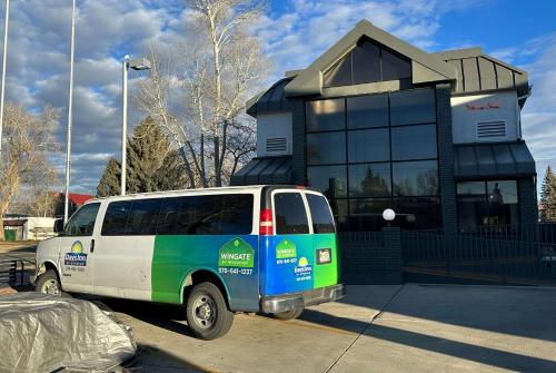 ガニソンにあるWingate by Wyndham Gunnison Near Western Colorado Universityの建物前に停車するバン