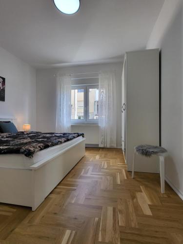 1 dormitorio blanco con 1 cama y suelo de madera en Check In Rebro en Zagreb