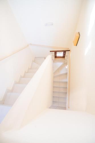 a staircase in a white room with a stair case at Villa Anna Gaia - Tsivaras in Chania Town