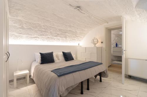 Un dormitorio con una cama en una habitación blanca. en La Porta Sul Mare- Timone, en Mola di Bari