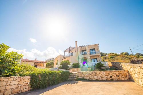 a house with a stone wall in front at Villa Anna Gaia - Tsivaras in Chania Town