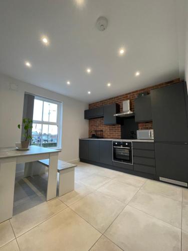 a large kitchen with a table and a window at Manchester City luxury hideaway in Urmston
