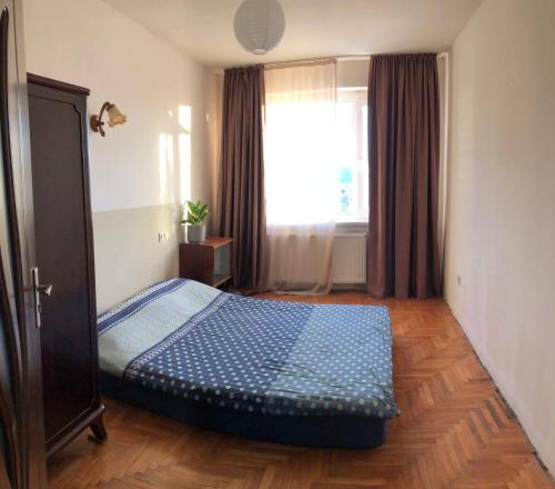 een slaapkamer met een bed voor een raam bij Vazi156 in Tbilisi City