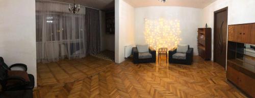 een woonkamer met 2 stoelen, een tafel en een televisie bij Vazi156 in Tbilisi City