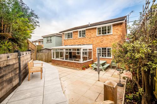 a garden with a patio in front of a house at Pass the Keys Stunning waterside retreat with estuary views in Exeter