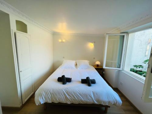 - une chambre dotée d'un lit avec deux chaussures noires dans l'établissement Biarritz hyper centre - Halles - terrasse, à Biarritz