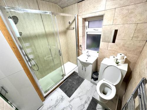 een badkamer met een douche, een toilet en een wastafel bij Lucky Fives at Castle Road in Birmingham