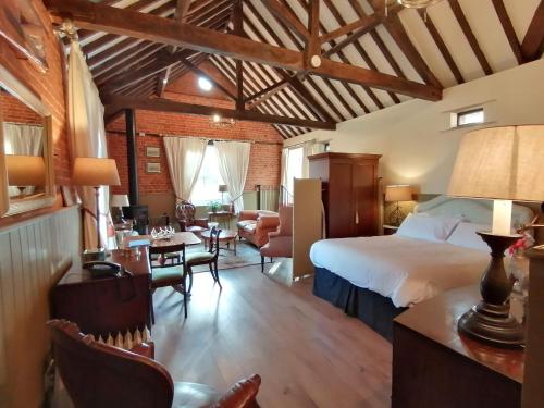 um quarto com uma cama e uma sala de estar em Carrick's at Castle Farm em Swanton Morley