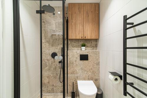 a bathroom with a shower with a toilet at #stayhere - New & Stylish Minimalistic 1BDR Vilnius City Center in Vilnius