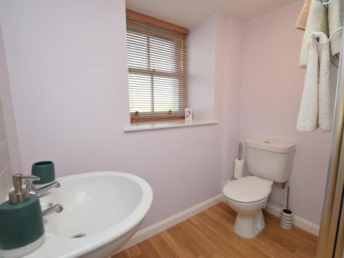 een witte badkamer met een toilet en een wastafel bij 1 Bed in Morebattle 52538 in Morebattle