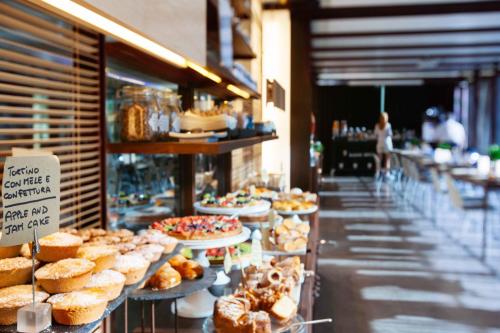 a bakery aisle with a bunch of pastries on display at UNA HOTELS One Siracusa in Siracusa