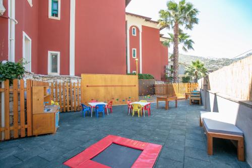 a patio with tables and chairs and a red building at Grand Aquarium in Marmaris
