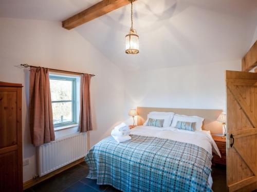 a bedroom with a bed with a checkered blanket at 2 bed in Conwy Valley SKN09 in Llanrwst
