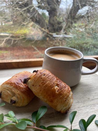 a cup of coffee and two croissants next to a window at Old Hundred View in Tormarton