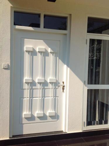 a white door with a railing on it at Elegance Villa in Boralesgamuwa