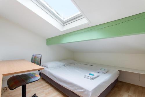 a bedroom with a bed and a desk and a skylight at Bidart - balcon - Proche plage in Bidart