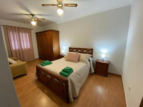 a bedroom with a bed with two green towels on it at Casa Kanete in Cala