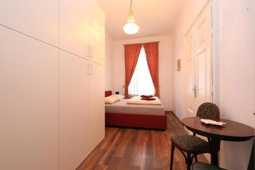 Cette petite chambre comprend un lit, une table et des chaises. dans l'établissement Alan's Downtown Apartment, à Zagreb