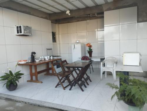 a kitchen with a table and chairs and a refrigerator at Pousada Sol da Justiça in Campos dos Goytacazes