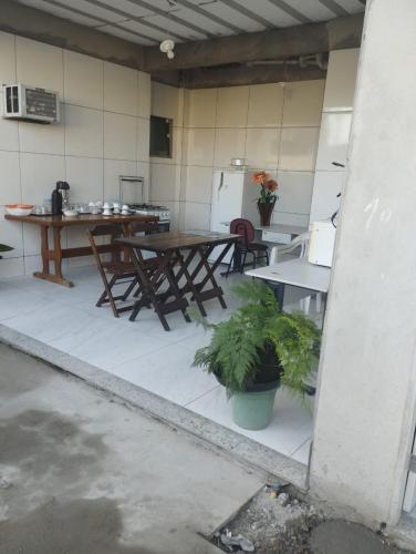 uma cozinha com mesas e cadeiras num quarto em Pousada Sol da Justiça em Campos dos Goytacazes