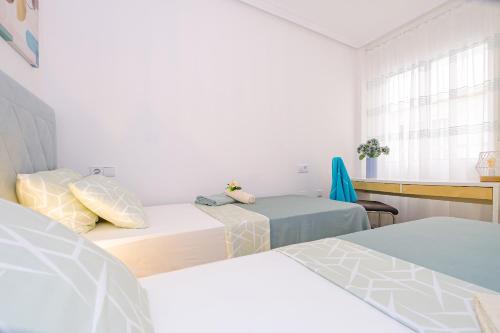 una camera da letto con due letti e una finestra di Home&Holiday Goleta with parking-option a Torrevieja