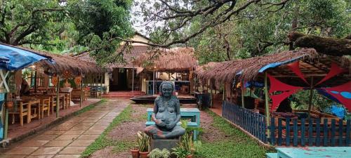 uma estátua sentada no quintal de um restaurante em Gaia Hostels em Anjuna