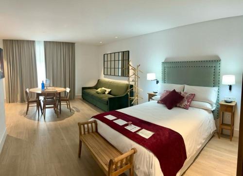 una habitación de hotel con una cama grande y una mesa en Apartamentos Turísticos La Plaza, en Chipiona
