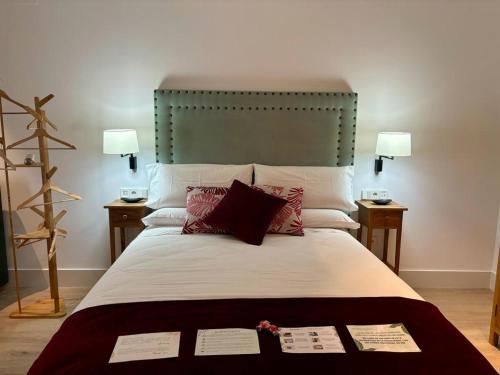 a bedroom with a large bed with two tables at Apartamentos Turísticos La Plaza in Chipiona