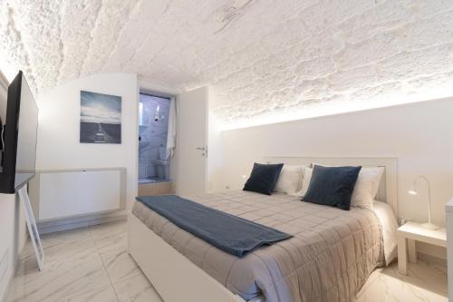 een witte slaapkamer met een bed in een kamer bij La Porta Sul Mare in Mola di Bari
