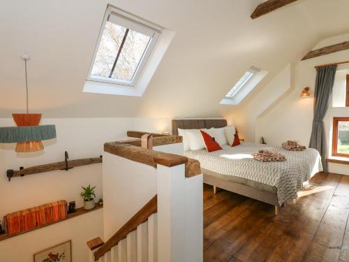 a attic bedroom with a bed and a staircase at The Little Hay Barn in Norwich