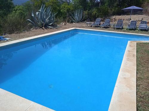 ein blauer Pool mit Stühlen im Hof in der Unterkunft Masia Rustica Costa Brava in Calonge
