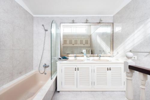 - Baño blanco con 2 lavabos y ducha en EK Abades El Caleton, en Abades